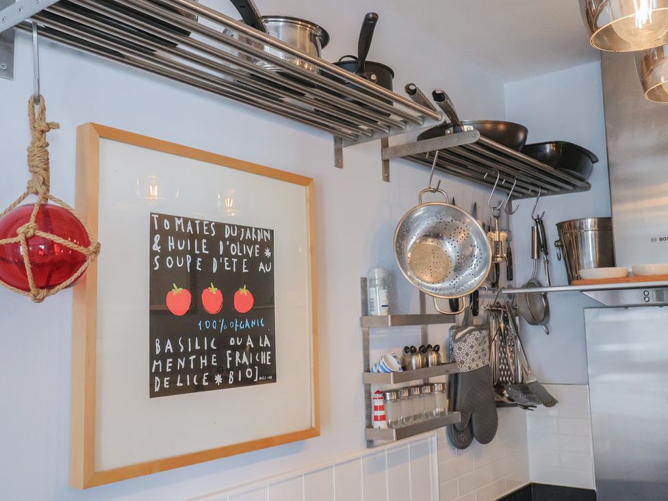 A kitchen with cooking utensils and framed art at Seaside in Lyme Regis