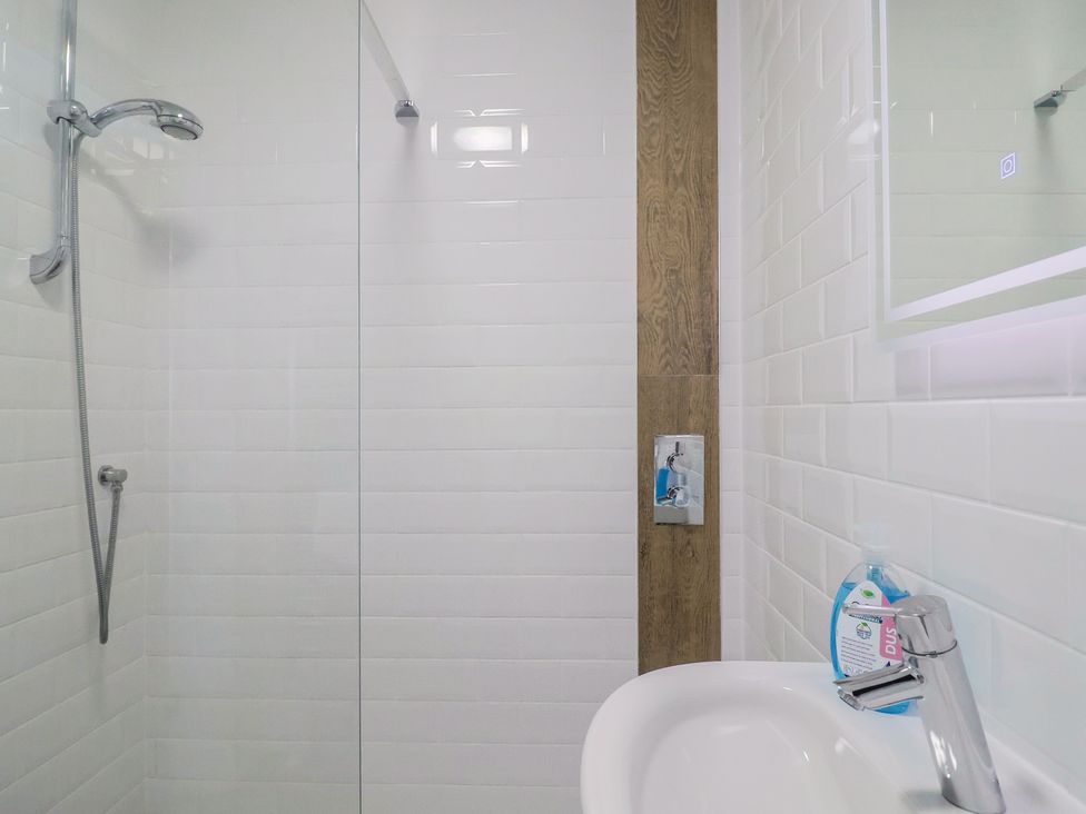 A bathroom with a shower and sink at Seaside in Lyme Regis