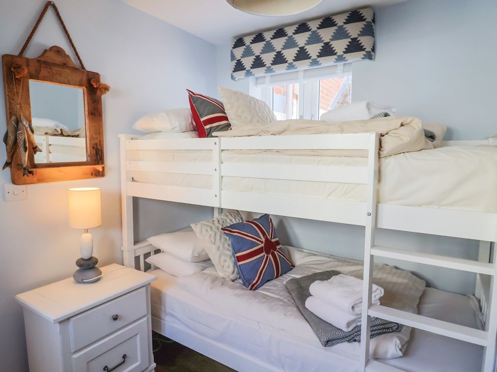 A bedroom with a bunk bed and a nightstand at Seaside in Lyme Regis