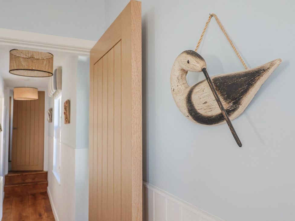 A hallway with a wooden door and wall art at Seaside in Lyme Regis