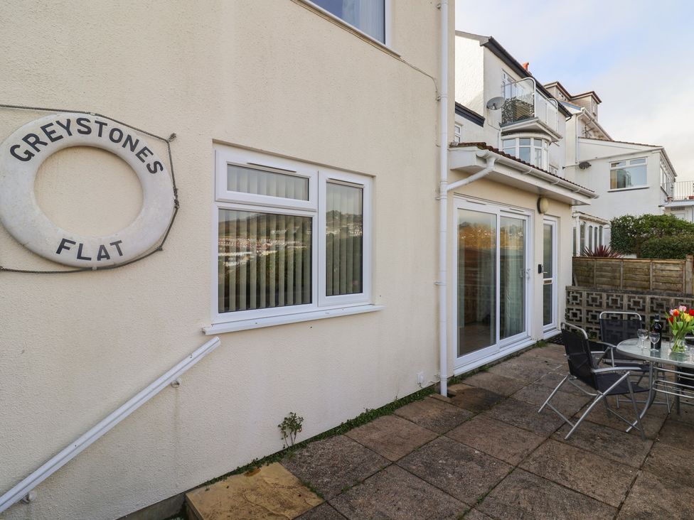 An outdoor area with seating and a sign at Greystones Flat in Lyme Regis