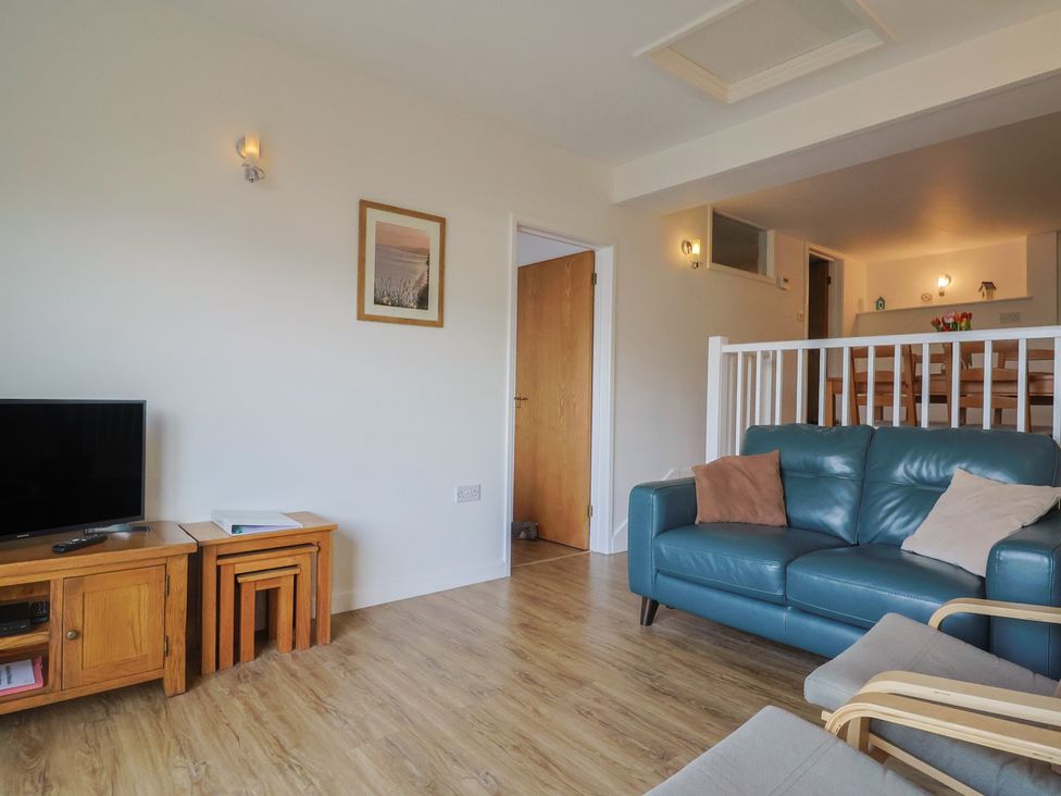 A living room with a sofa and television at Greystones Flat in Lyme Regis