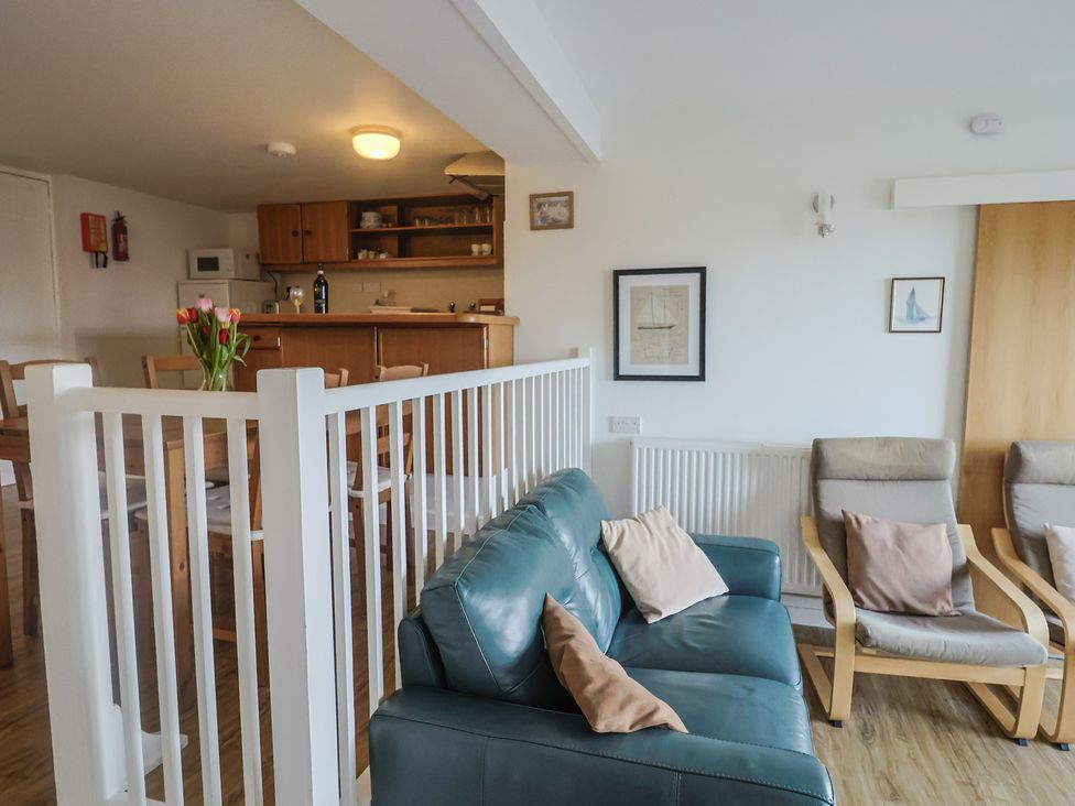 A living room with a sofa and dining table at Greystones Flat in Lyme Regis