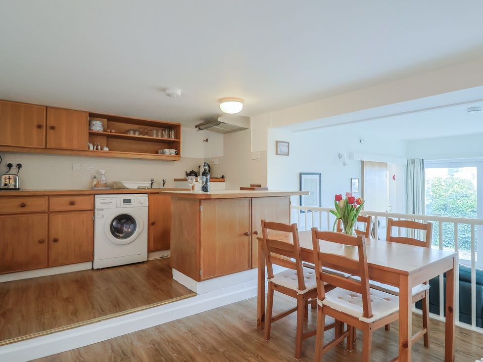 A kitchen and dining area with wooden furniture at Greystones Flat in Lyme Regis