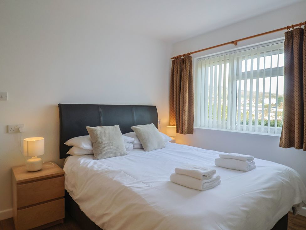 A bedroom with a double bed and a bedside table at Greystones Flat in Lyme Regis