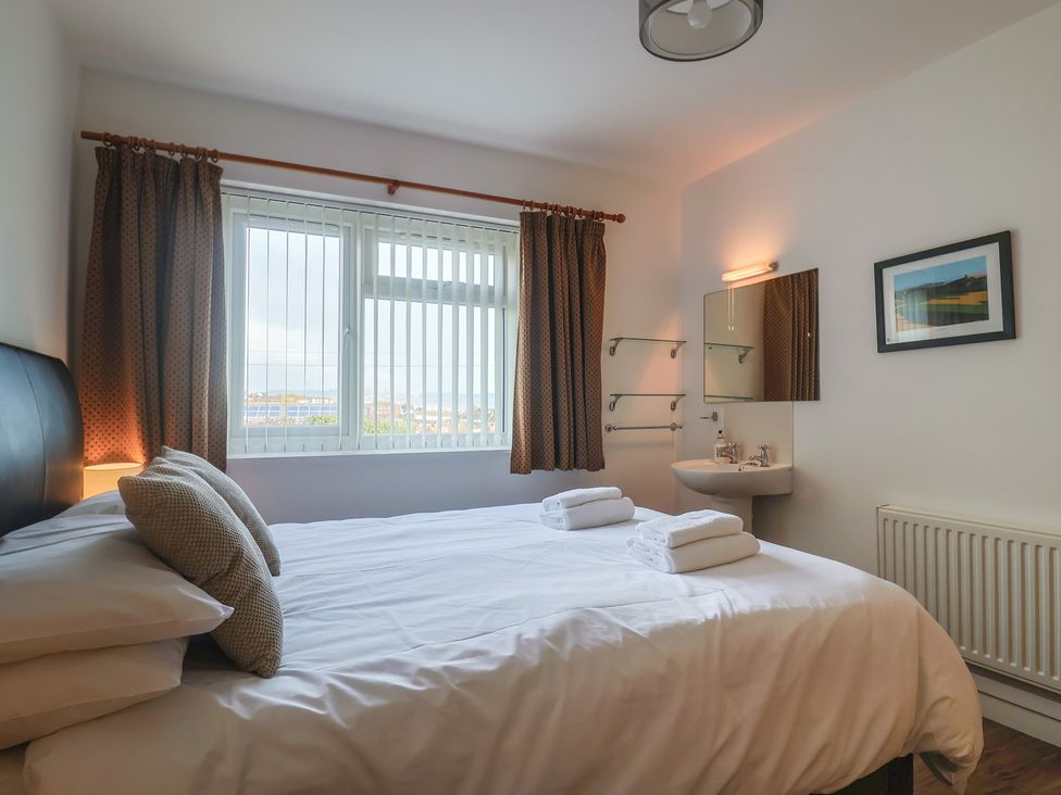 A bedroom with a bed and sink at Greystones Flat Lyme Regis