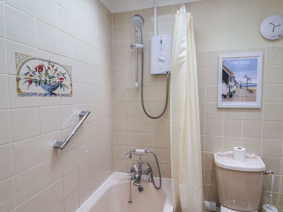 A bathroom with a bathtub and toilet at Blacksmiths Cottage in Lyme Regis