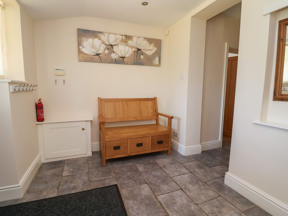 A hallway with a bench and fire extinguisher at 4 Green Farm Cottage Saughall