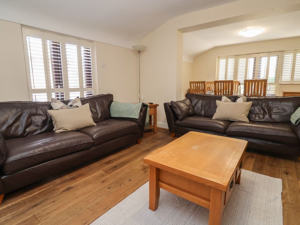 A living room with sofas and a table at 4 Green Farm Cottage Saughall