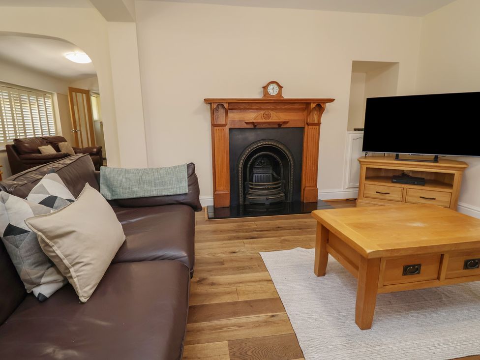 A living room with a fireplace and television at 4 Green Farm Cottage in Saughall