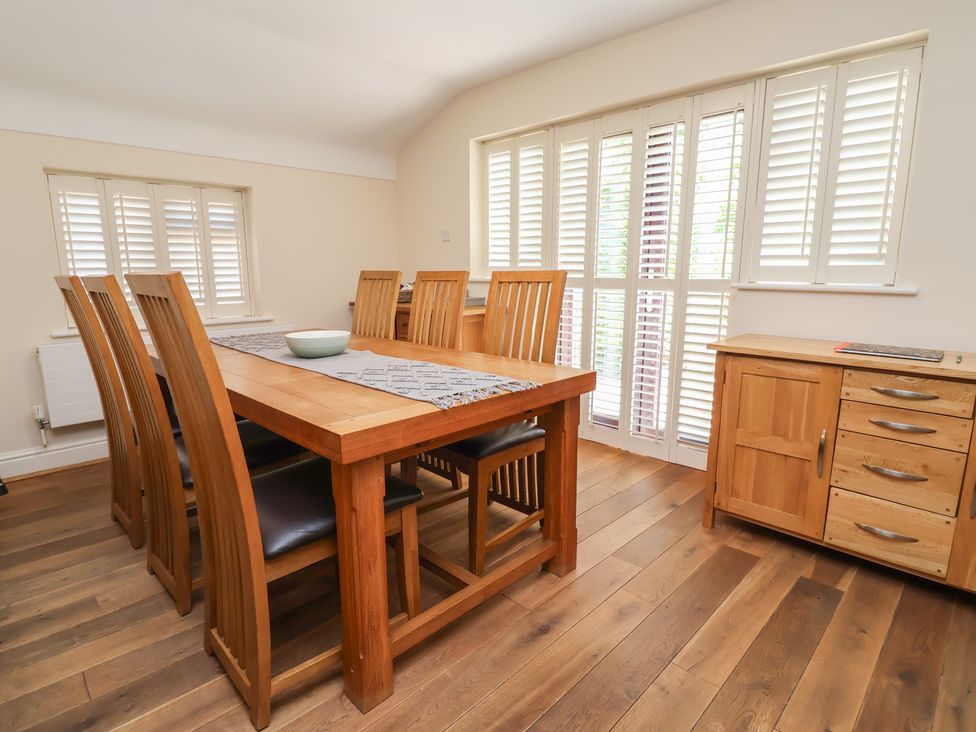 A dining room with a table and chairs at 4 Green Farm Cottage Saughall