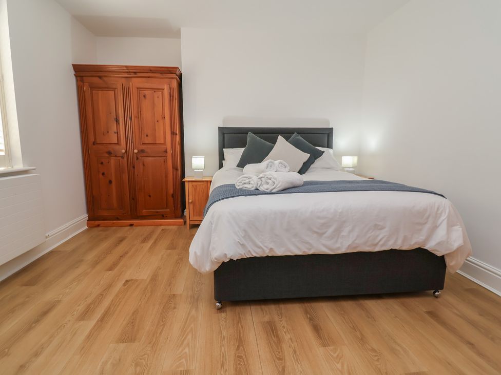 A bedroom with a bed and wardrobe at 4 Green Farm Cottage Saughall