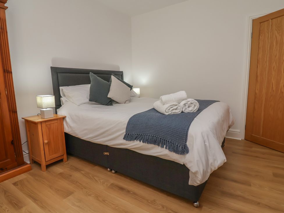 A bedroom with a bed and bedside table at 4 Green Farm Cottage in Saughall