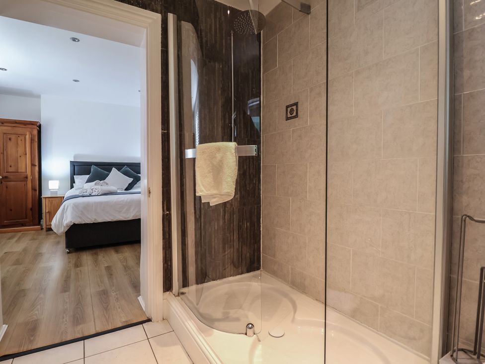 A shower with towel and glass door in a bathroom at 4 Green Farm Cottage in Saughall