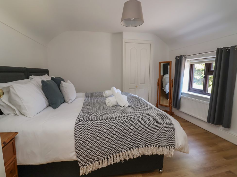 A bedroom with a bed and mirror at 4 Green Farm Cottage Saughall