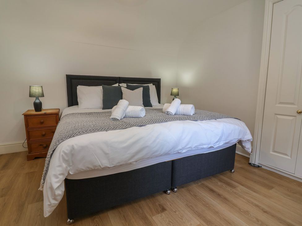 A bedroom with a bed and nightstand at 4 Green Farm Cottage Saughall