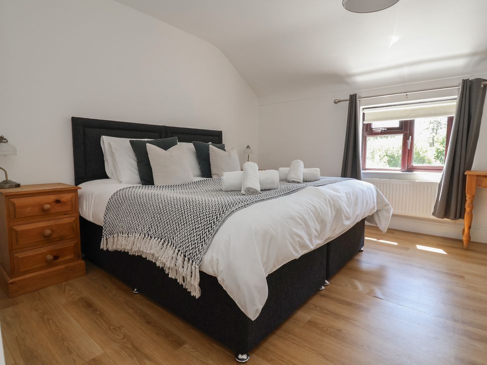 A bedroom with a bed and bedside table at 4 Green Farm Cottage Saughall