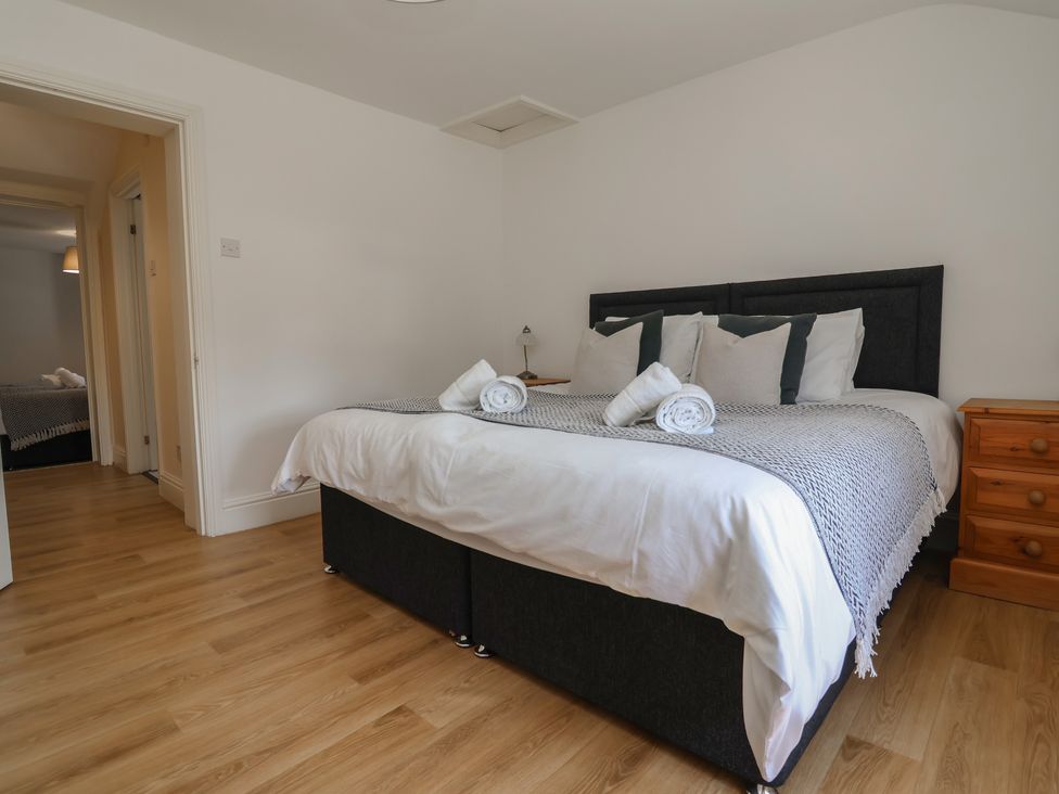 A bedroom with a bed and nightstand at 4 Green Farm Cottage Saughall