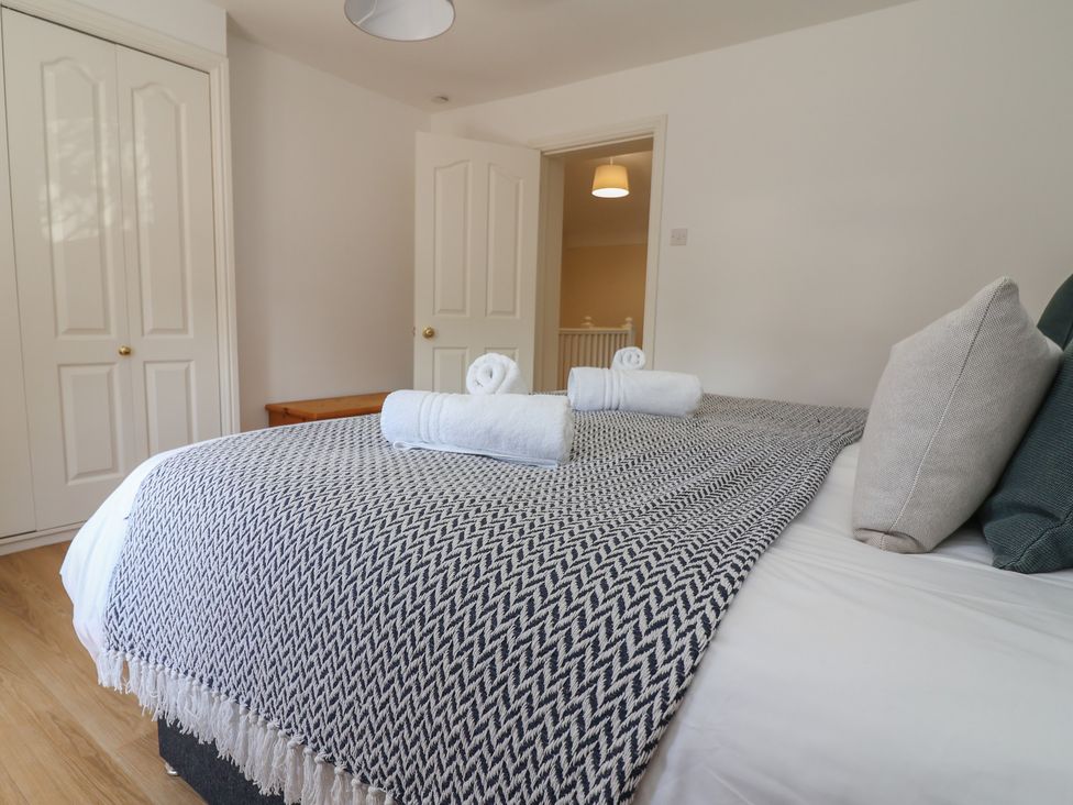 A bedroom with a bed and towels arranged at 4 Green Farm Cottage in Saughall