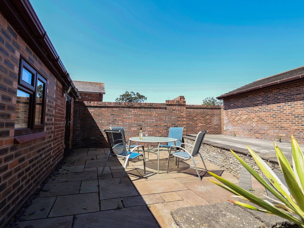 A patio area with a table and chairs at 4 Green Farm Cottage in Saughall