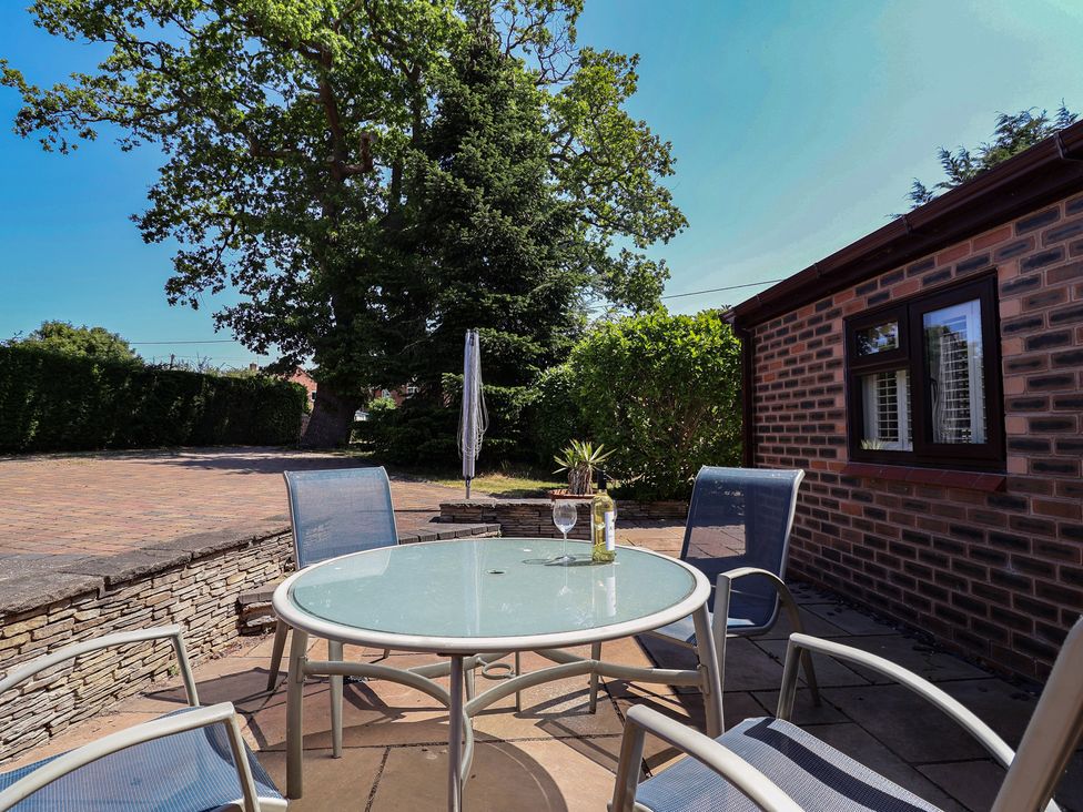A patio area with a table and chairs at 4 Green Farm Cottage Saughall