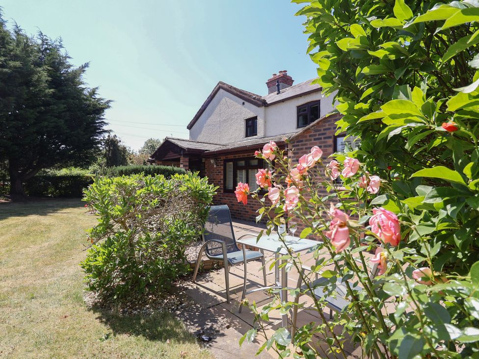 A garden with roses and patio furniture at 4 Green Farm Cottage Saughall