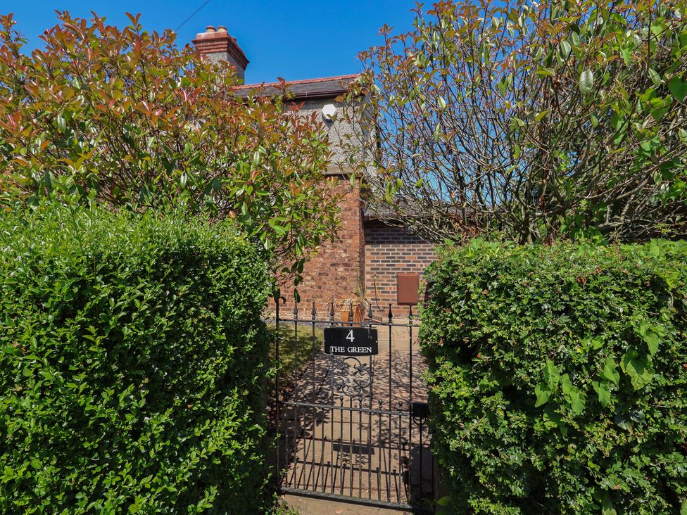 A gate with a sign at the entrance of 4 The Green in Saughall