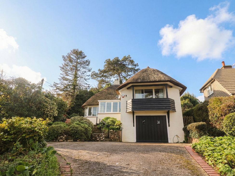 A house with a thatched roof and driveway at Maries in Lyme Regis