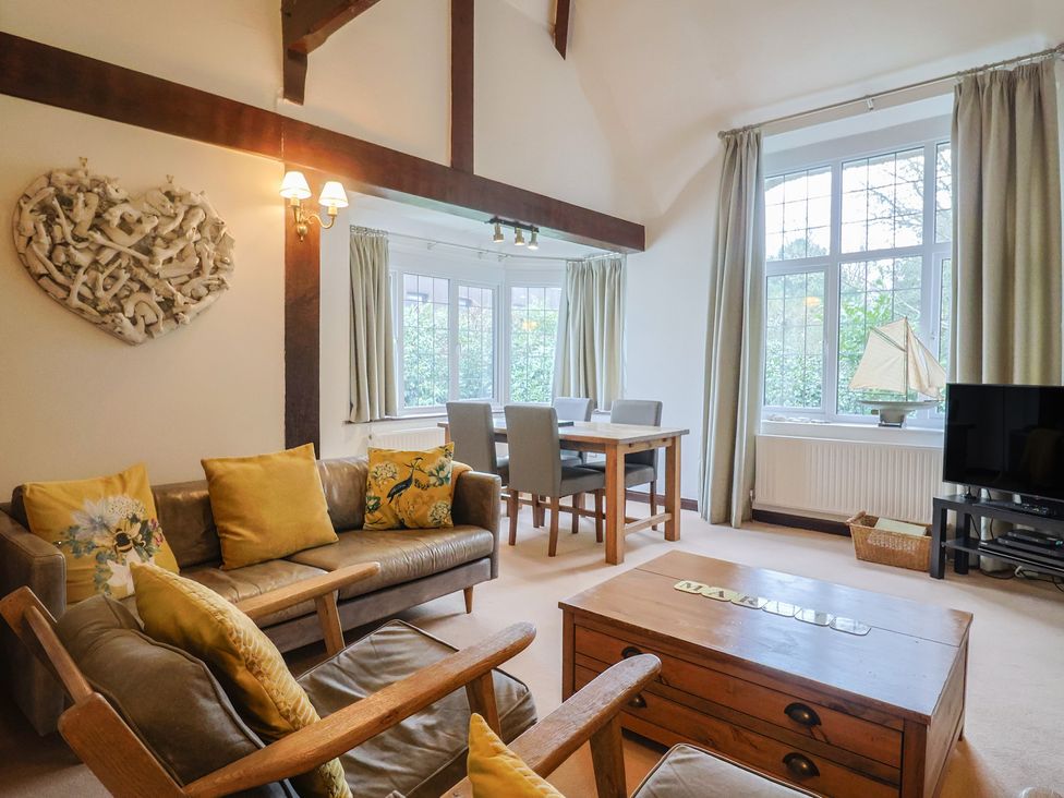 A living room with a coffee table and dining area at Maries in Lyme Regis