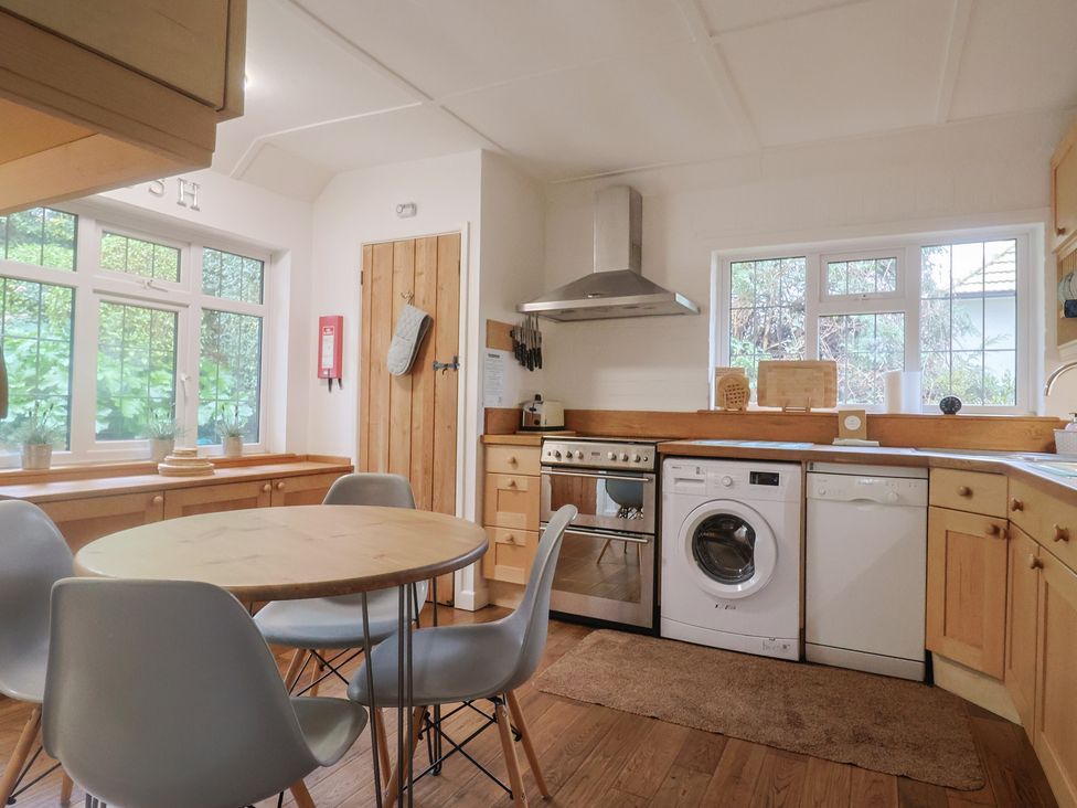 A kitchen with a round table and appliances at Maries in Lyme Regis