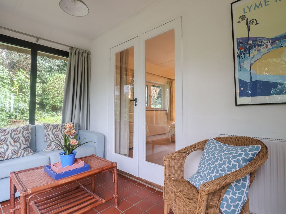 A conservatory with a sofa and coffee table at Maries in Lyme Regis