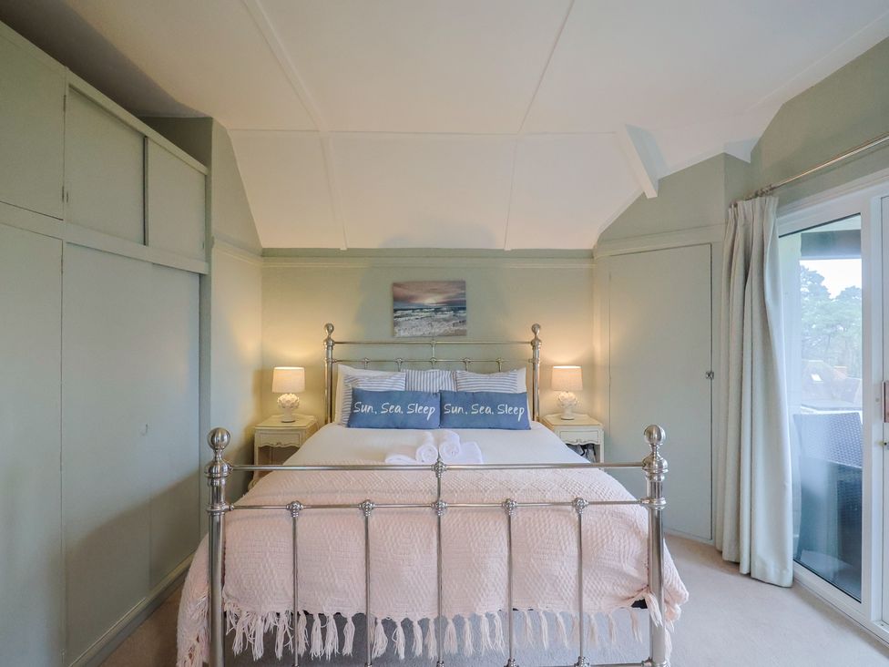 A bedroom with a bed and nightstands at Maries in Lyme Regis