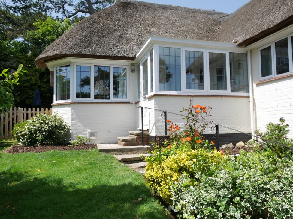 A garden with stone steps and a thatched roof at Maries in Lyme Regis