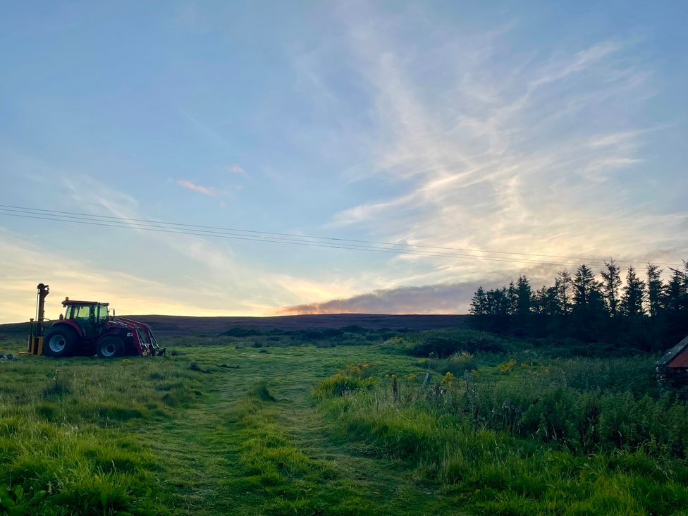 A field with a tractor and trees at Ceol-na-Mara Newport near Dunbeath