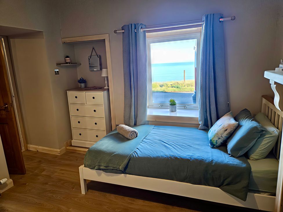 A bedroom with a bed and window at Ceol na Mara Newport near Dunbeath