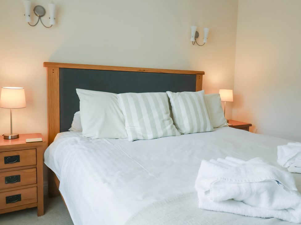 A bedroom with a bed and bedside lamps at The Bolthole in Lyme Regis