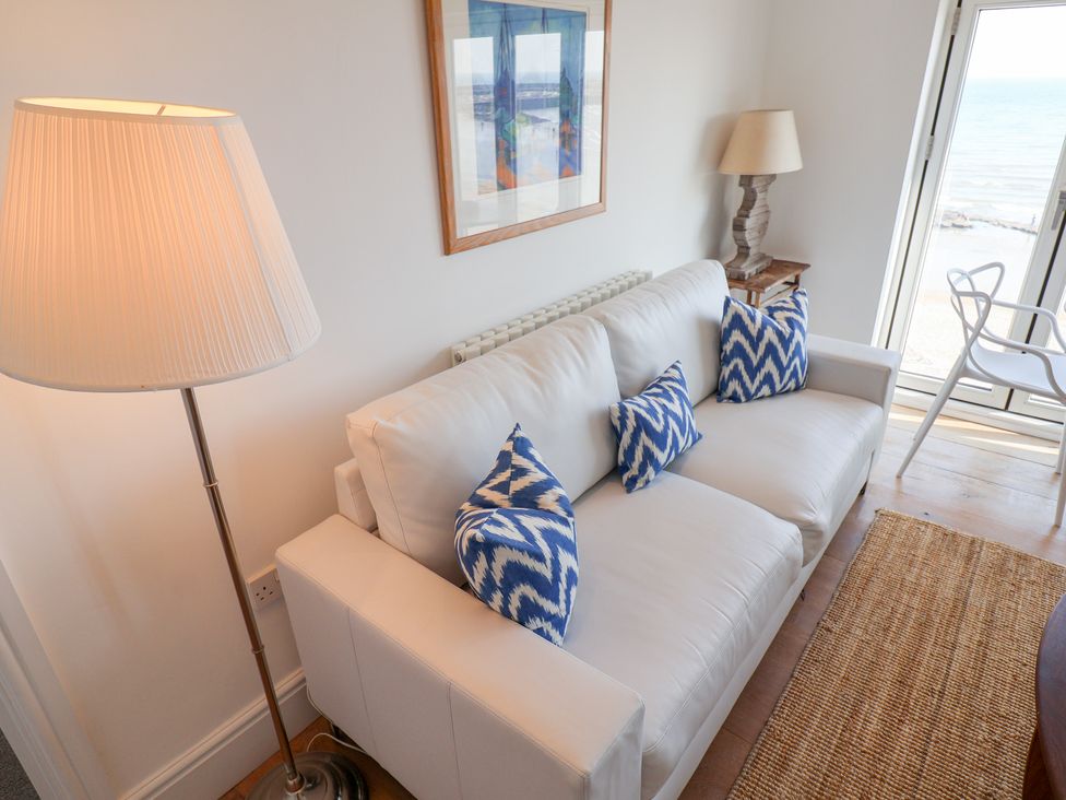 A living room with a sofa and lamp at Seagull in Lyme Regis