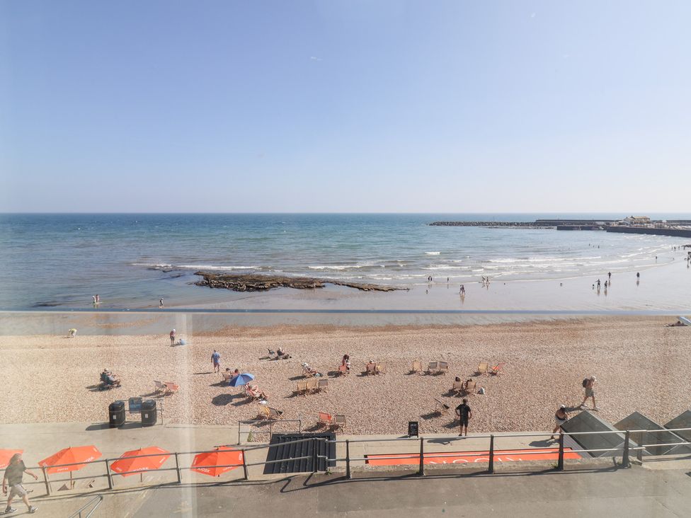 A beach scene with people and an ocean view at Seagull in Lyme Regis