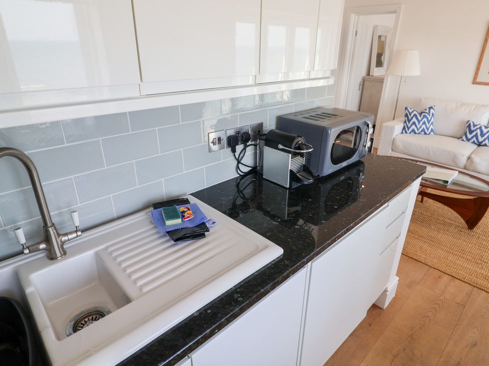 A kitchen with a sink and microwave at Seagull in Lyme Regis