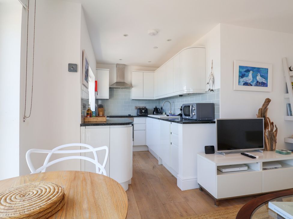 A kitchen with appliances and seating at Seagull in Lyme Regis