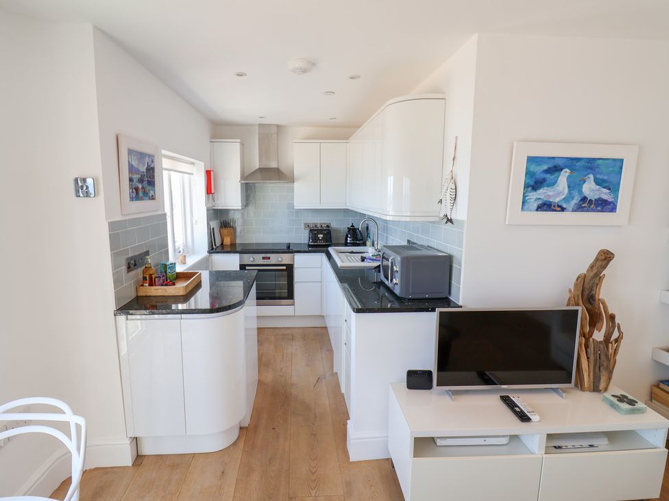A kitchen with cabinets, oven, and microwave at Seagull in Lyme Regis