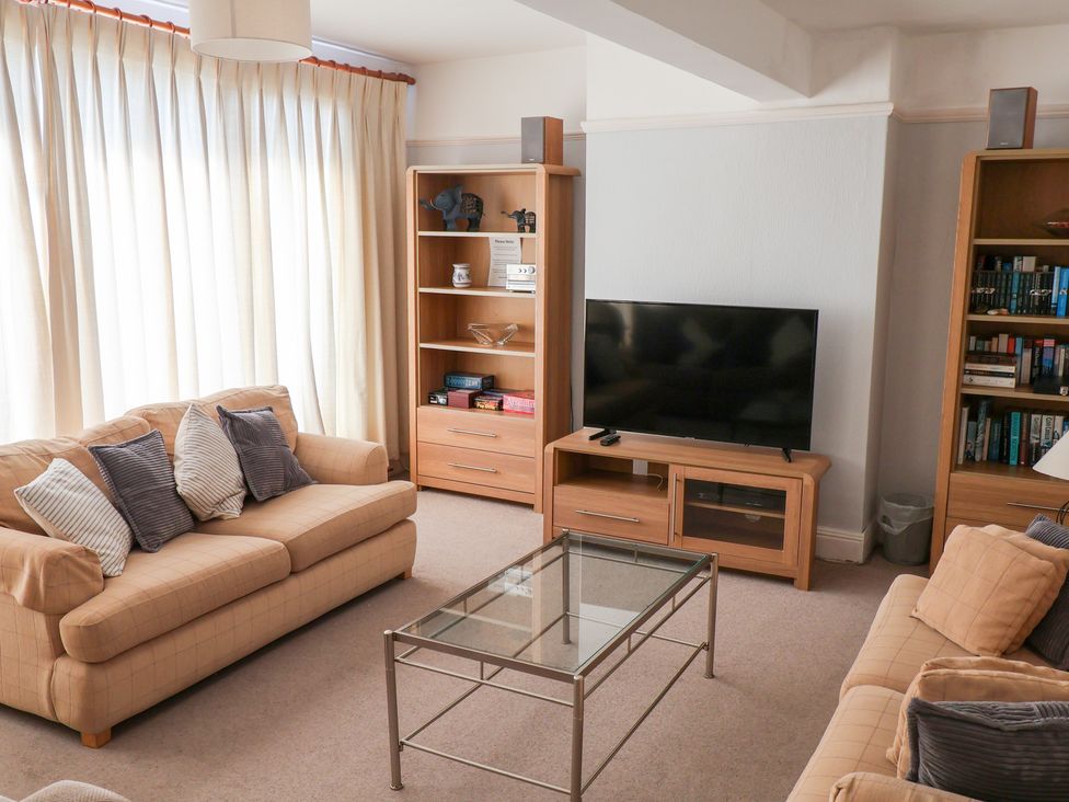 A living room with a sofa, coffee table and television at Watersmeet in Lyme Regis