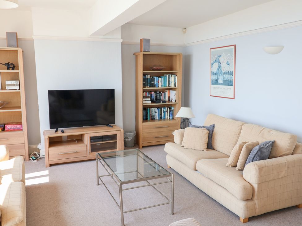 A living room with a television and a bookshelf at Watersmeet in Lyme Regis