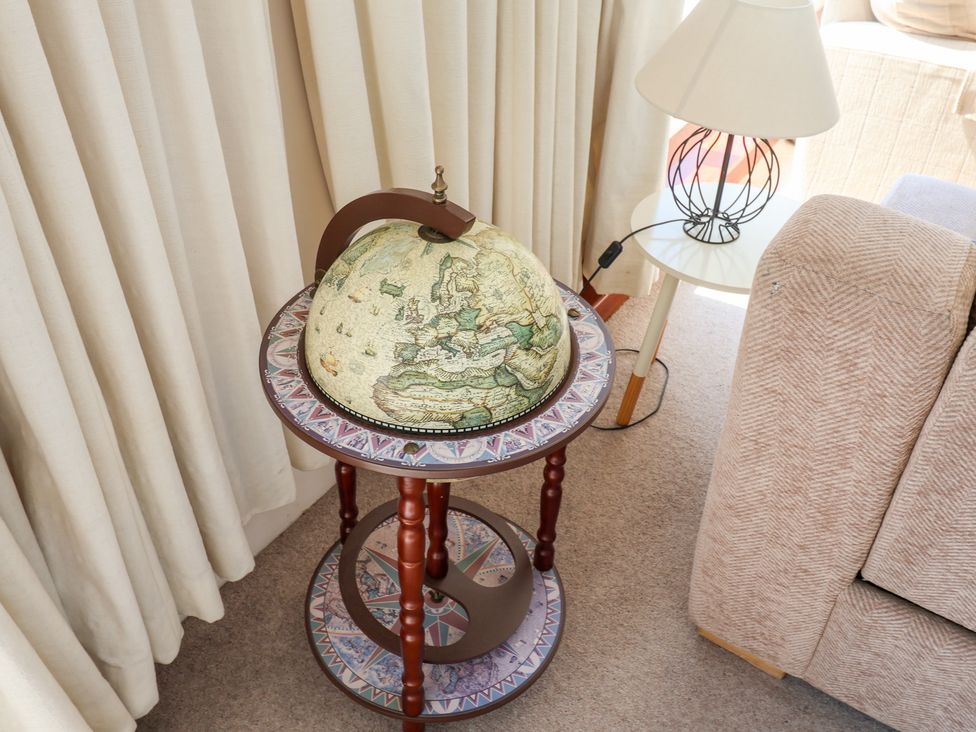 A globe on a table next to a lamp and sofa at Watersmeet in Lyme Regis