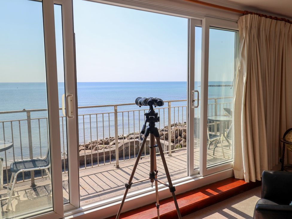 A living room with a telescope overlooking the sea at Watersmeet in Lyme Regis