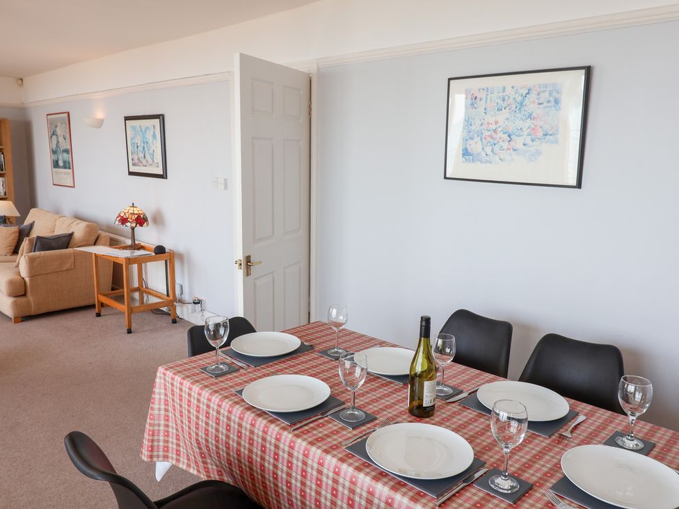 A dining room with a table set for dinner at Watersmeet in Lyme Regis