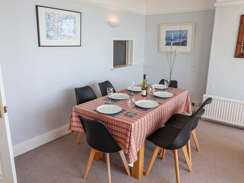 A dining room with a table set for dinner at Watersmeet in Lyme Regis