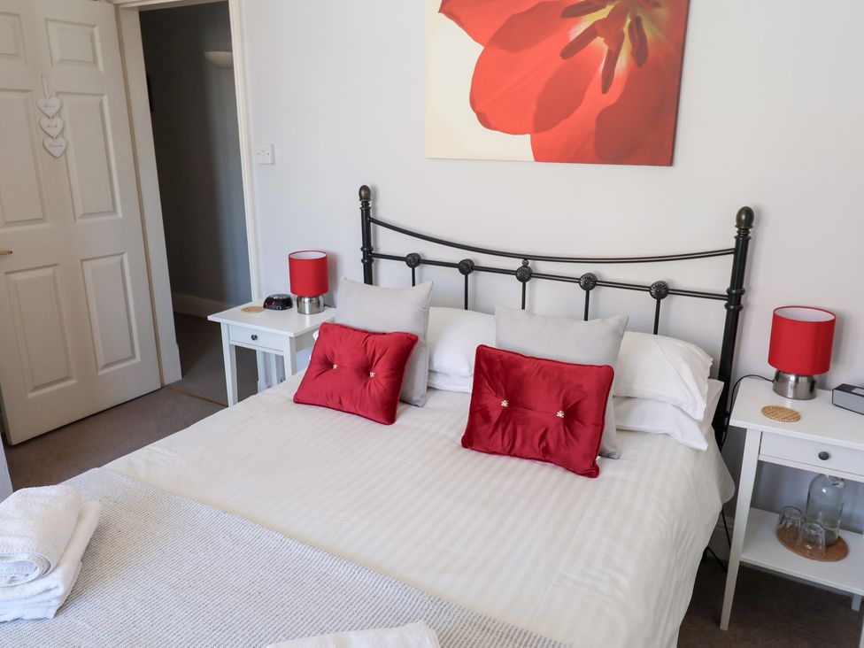 A bedroom with a bed and bedside tables at Watersmeet Lyme Regis