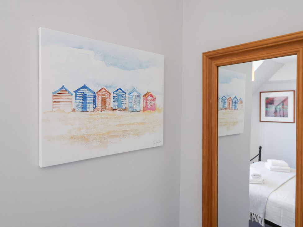 A bedroom with a painting and a mirror at Watersmeet in Lyme Regis