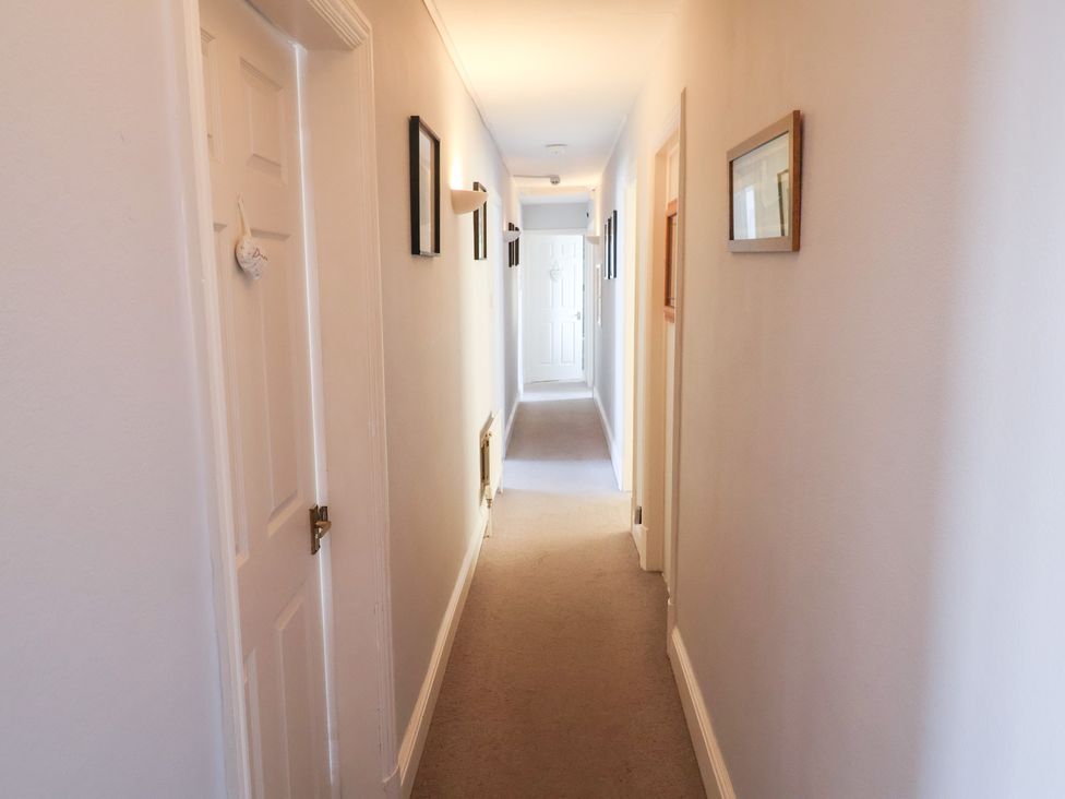 A hallway with doors and pictures at Watersmeet in Lyme Regis